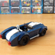 Illustration for article titled This Cool Fan-Made LEGO Iron Man Garage Has Some Great Models Of The Audi R8 And AC Cobra, Too